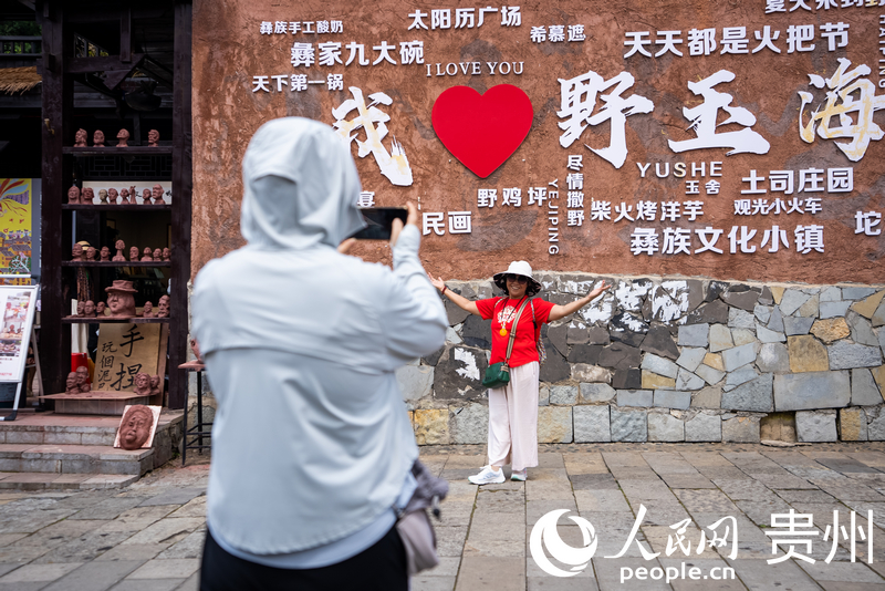 游客在海坪彝族文化小鎮打卡拍照。人民網記者 涂敏攝