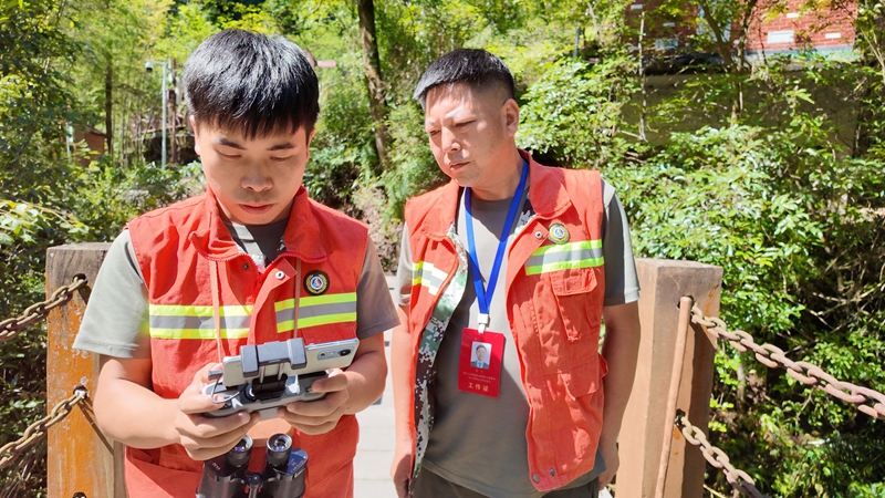 吳攀勝（左）認真的操作無人機。稅會靜攝
