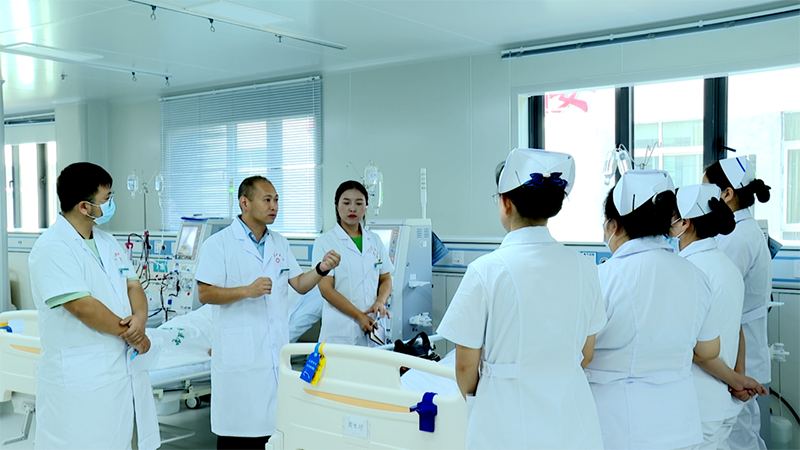 病房內，來自廣州市中西醫結合醫院的伍浩文醫生正帶領團隊查看病人情況，同時以這樣的實踐教學方式，向普定縣中醫醫院的醫護人員傳授專業知識，助力他們穩步成長。