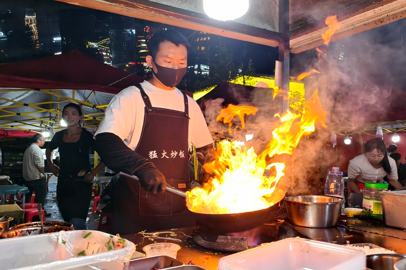 火把節系列活動期間，威寧城區會展中心夜攤生意火爆,商販在為顧客制作美食。岳剛攝