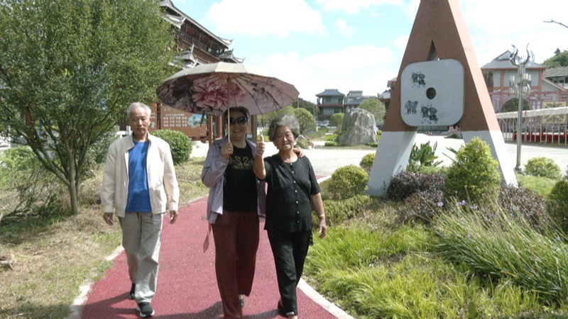 游客在三合苗寨散步。