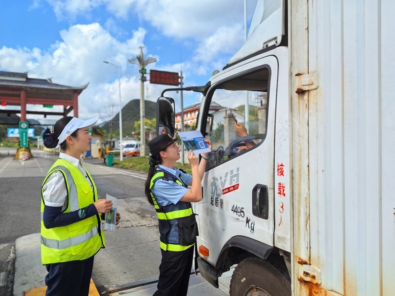 執法人員讓貨車司機掃碼提建議和意見。