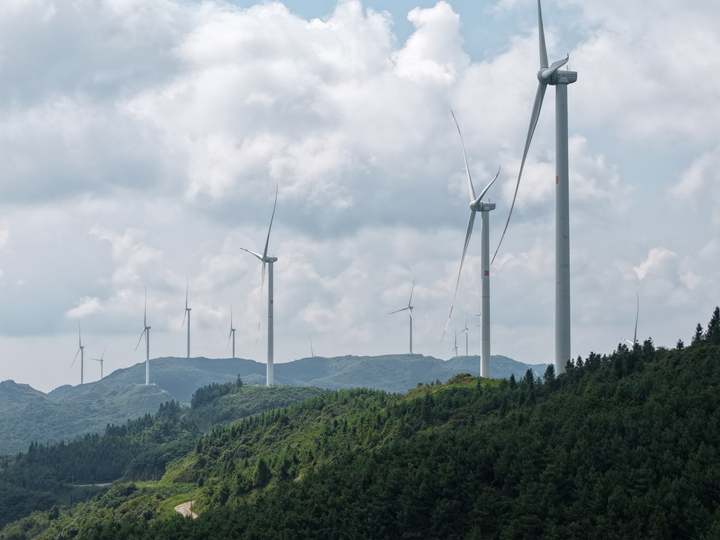 風機屹立山頂隨風而轉。