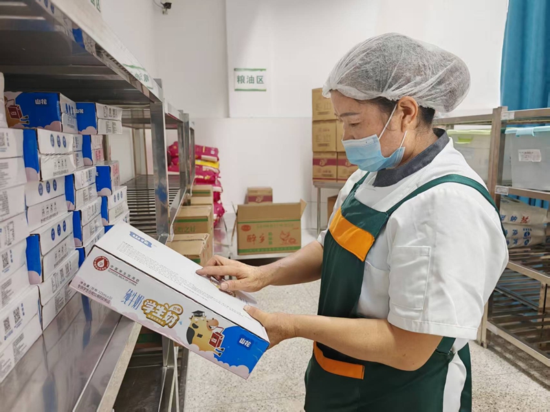 2、工作人員仔細查驗“學生奶”，確保食材安全。謝永恒  攝.jpg