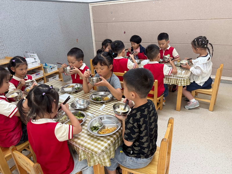 幼兒園孩子們在餐桌前開心用餐，氛圍溫馨。謝永恒  攝.jpg