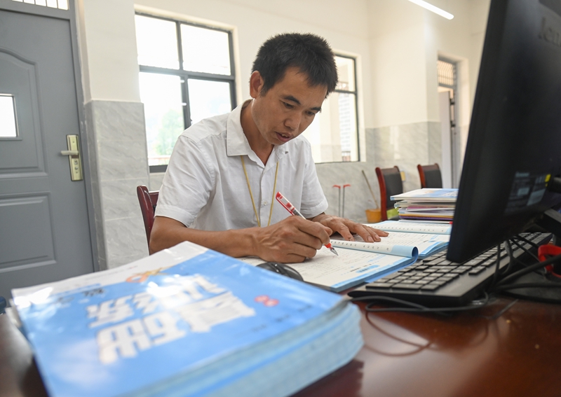 9月5日，松桃苗族自治縣迓駕鎮教師任達兵在批改作業。謝慧芳攝