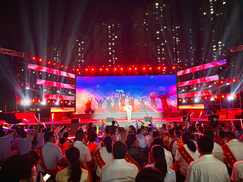 舞臺上表演者在絢麗背景與燈光下傾情演出，臺下觀眾熱情高漲，氛圍熱烈。張川 攝.jpg