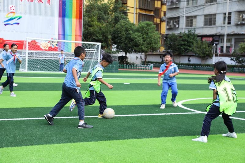 在劍河縣城關第三小學，孩子們在新足球場上踢足球。劉夢攝