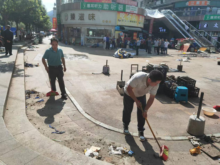 圖為攤販搬移后，附近居民主動上前打掃衛生。