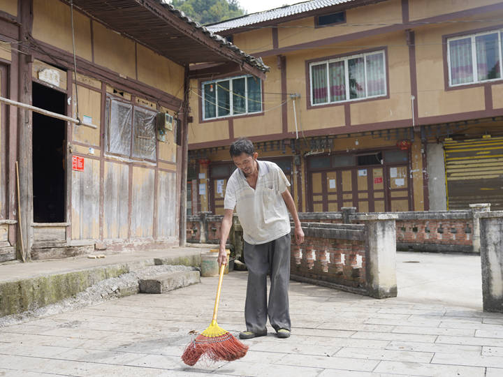 圖為 太壩村村民在打掃房前屋后的環境衛生。楊維攝