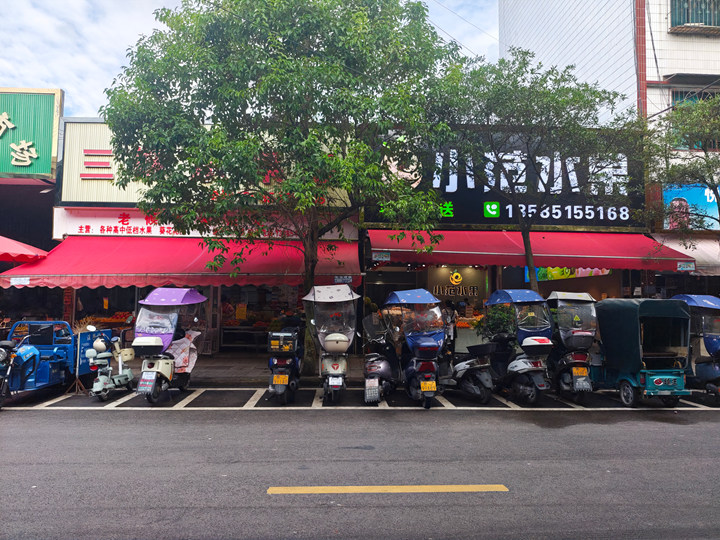 貴定縣荷花綜合市場門口整齊擺放的電動車。