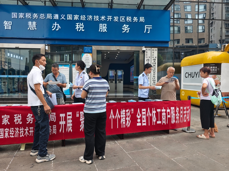 稅務干部發放個體工商戶稅收優惠折頁手冊(王寧 攝)