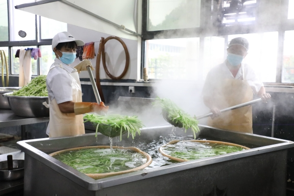 工人在給佛手瓜焯水。