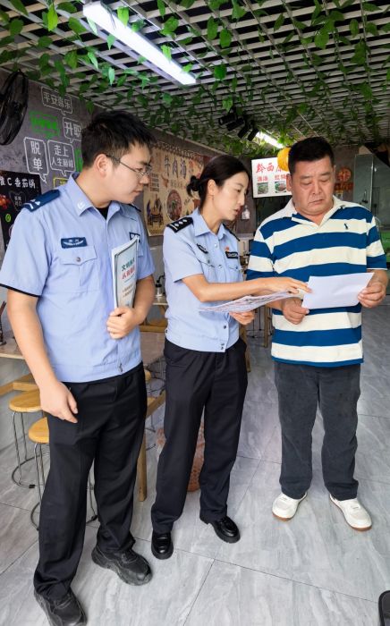 輔警向轄區群眾發放文明養犬宣傳資料。