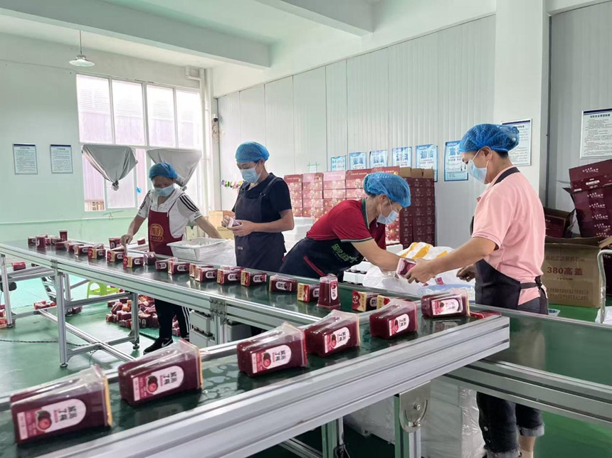 貴州黔滋梅食品有限公司工人在撿裝楊梅汁產品。鄢永華 、攝