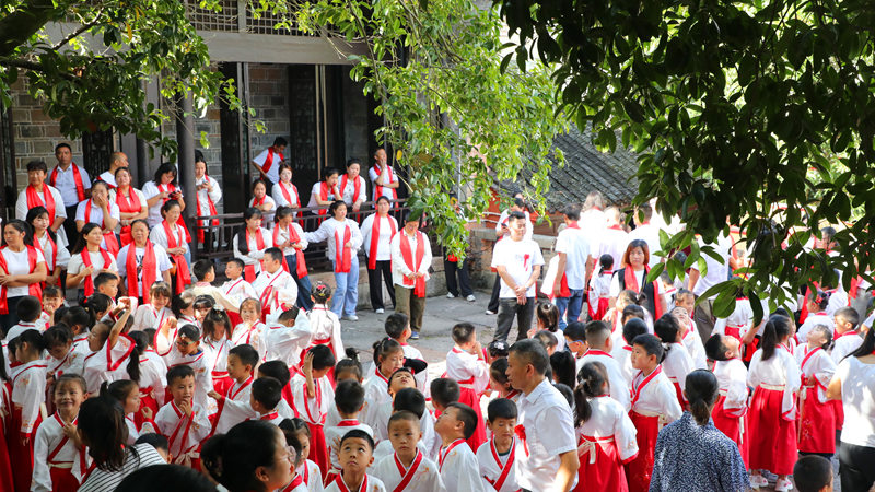 石阡縣府文廟院內兩株桂花樹下，學生和家長遮陽。陳超攝