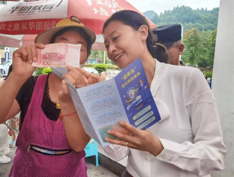 宣傳員手把手教商戶掌握人民幣防偽特征和假幣識別技巧。