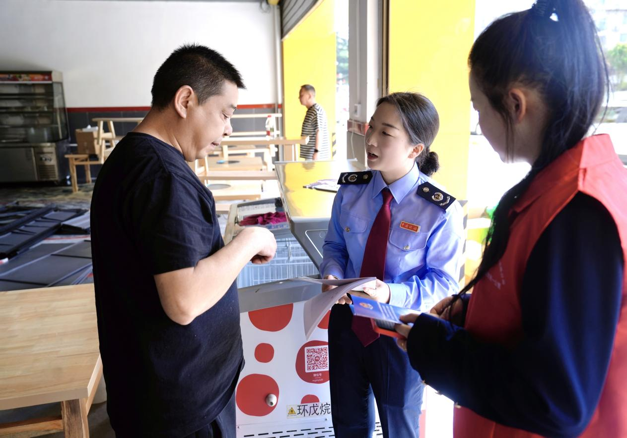 稅務干部向個體工商戶講解稅收優惠政策。毛忠崟攝