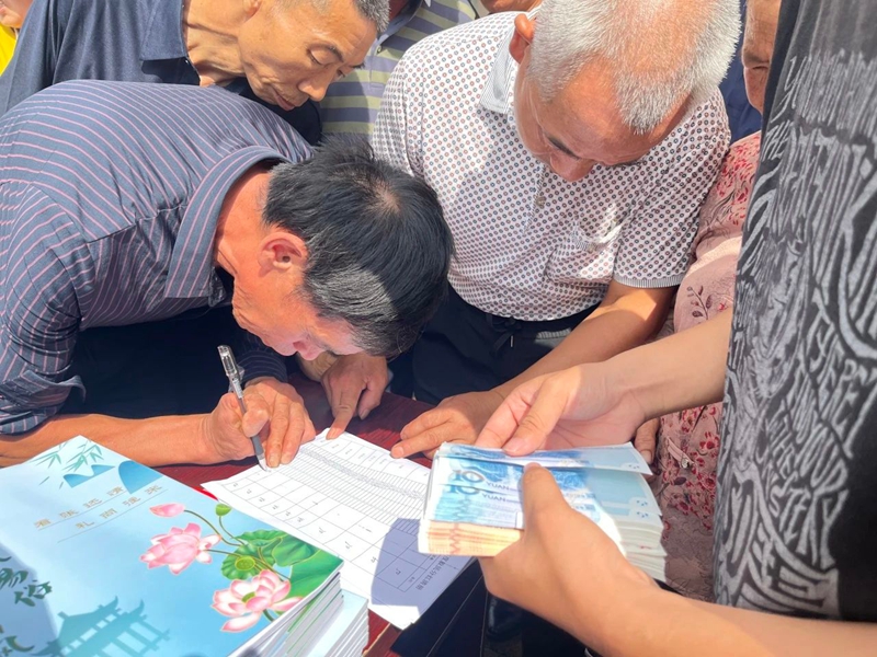 村民們滿心歡喜參與分紅，秩序井然。羅金 攝.jpg