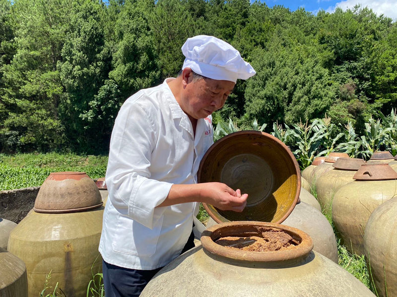 溫邦賢正在仔細查看醋醅成色。金莎攝