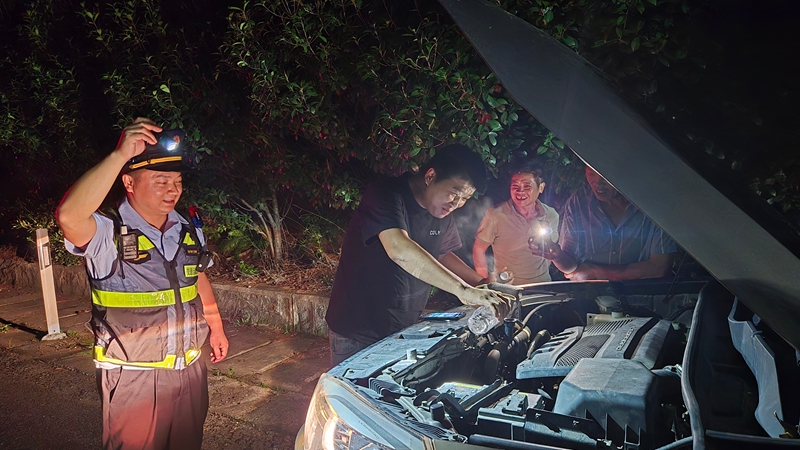 1 圖為貴州省交通運輸綜合行政執法七支隊十二大隊工作人員幫助司乘人員排除車輛故障問題。