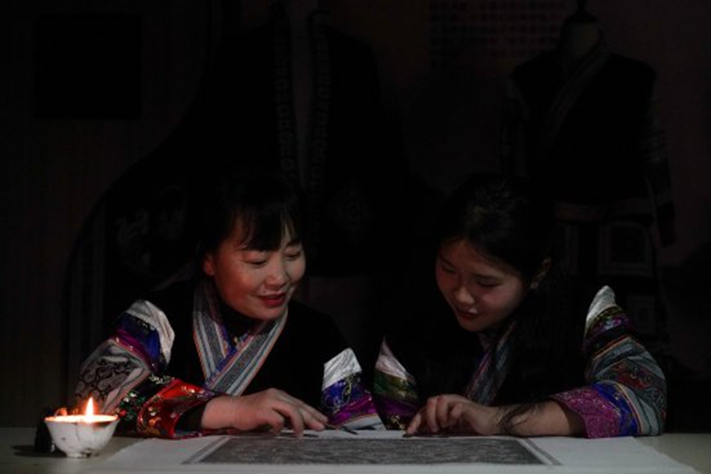 織金縣蔡群苗族蠟染刺繡有限公司總經理蔡群指導繡娘制作蠟染工藝品