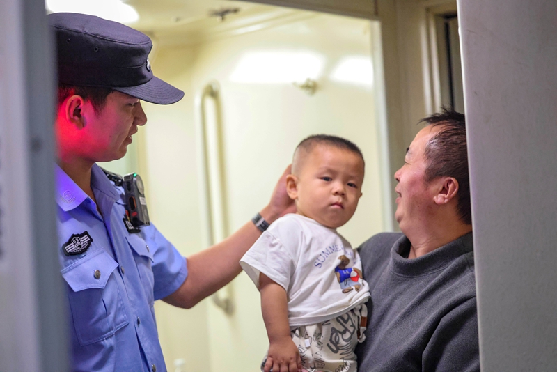 2025年10月15日，劉濤在K845次列車上與旅客交流.