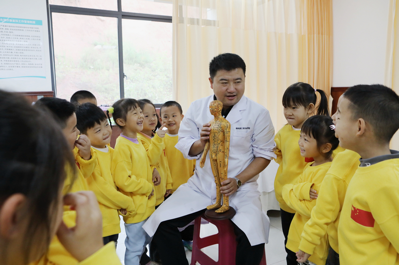 貴州省黔東南苗族侗族自治州施秉縣民族中醫院的醫生向縣第二幼兒園的小朋友們講解中醫藥知識。