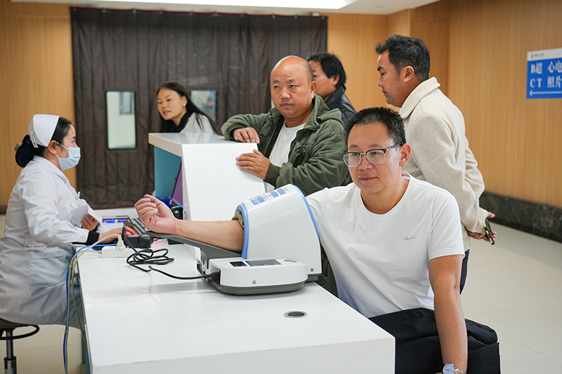 就診患者在分診臺測量血壓。胡璐攝