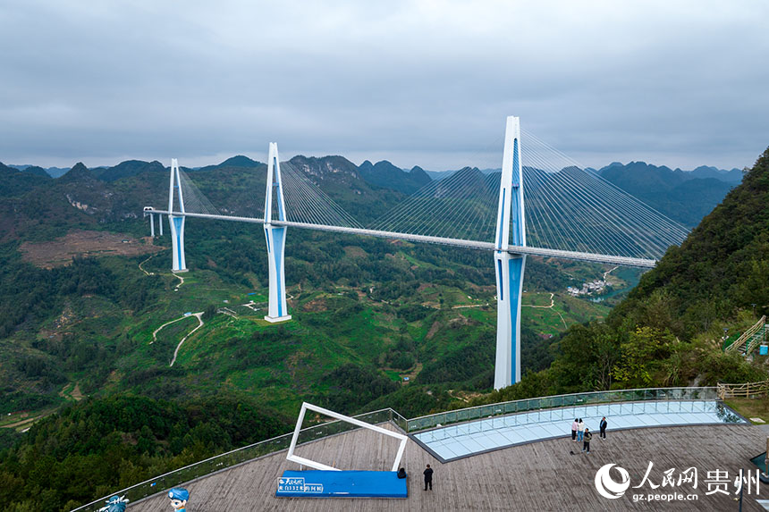 游客在“天空之橋”服務區觀景臺上觀賞大橋。人民網記者 涂敏攝