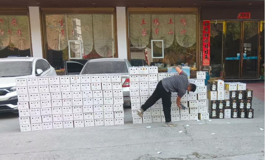 快遞員將領襪村百香果裝箱。