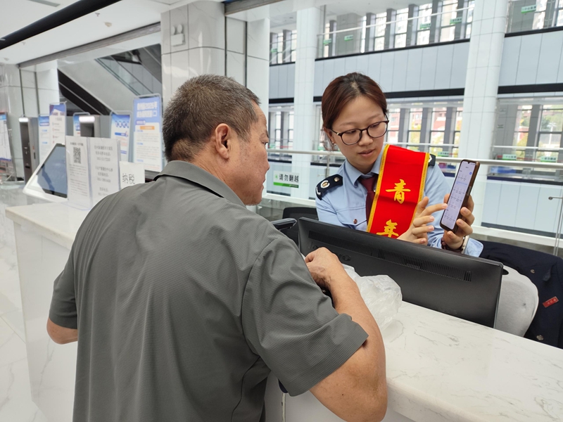 新蒲新區稅務局工作人員輔導納稅人“掌上辦”。 楊小萱供圖.jpg