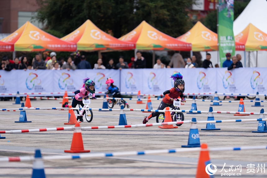 兒童滑步車項目比賽現場，小運動員在場地內展開激烈的追逐。人民網記者 涂敏攝