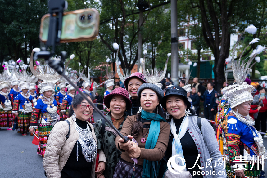 游客與非遺巡游隊伍合影。人民網記者 涂敏攝