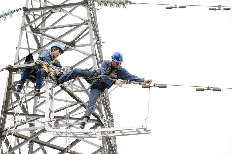 nEO_IMG_南方電網貴州興義供電局輸電管理所綜合數據班高級作業員龍福剛帶領徒弟應用自己研發的安全工具器在110千伏高壓輸電線路上開展檢修工作。盧關文攝